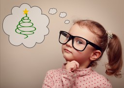 Cute kid girl in glasses thinking about gift on Christmas holiday. Vintage portrait