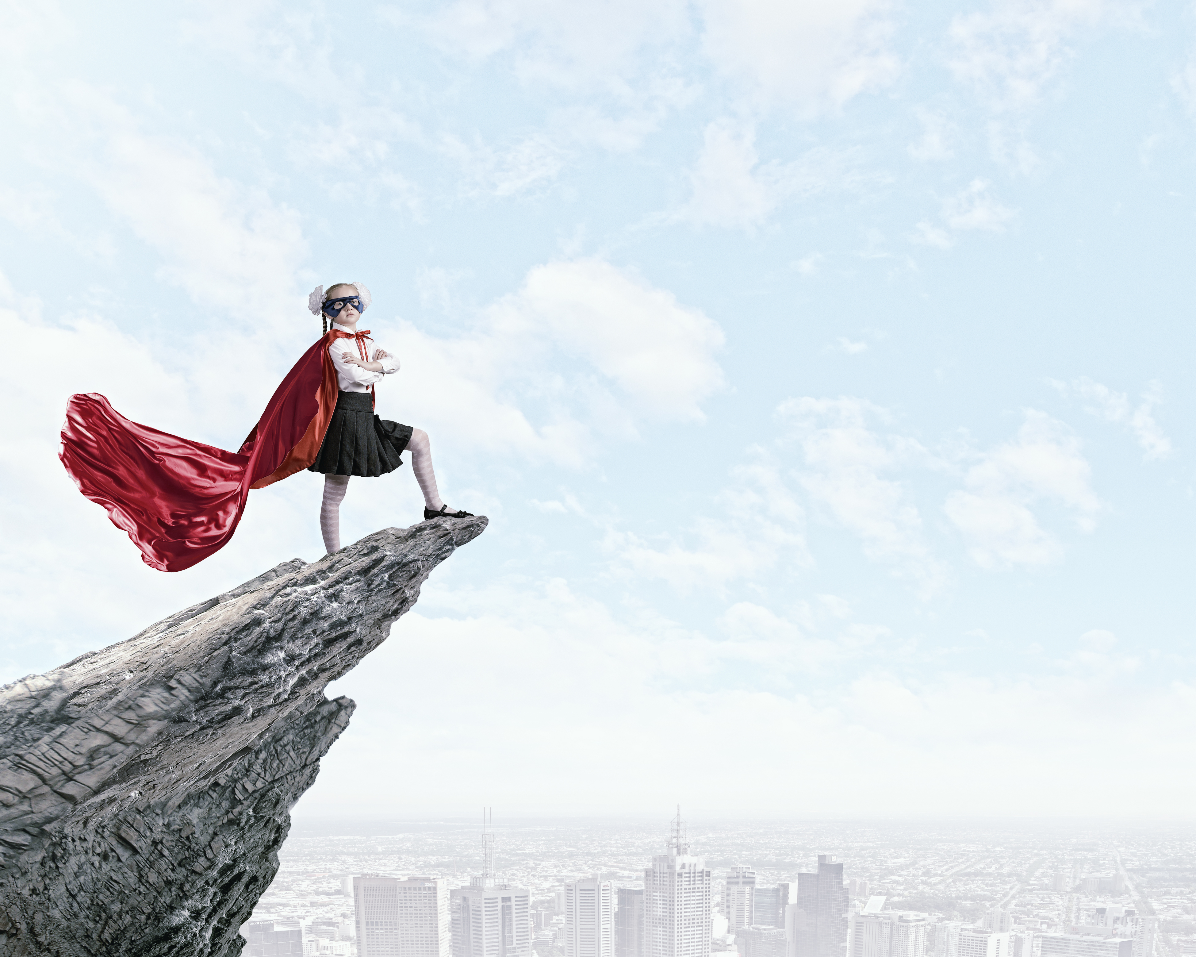 Cute girl of school age in superhero costume